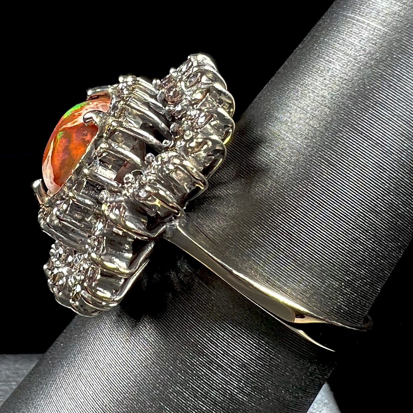 An 18k white gold orange fire opal ring set with a triple halo of diamonds.