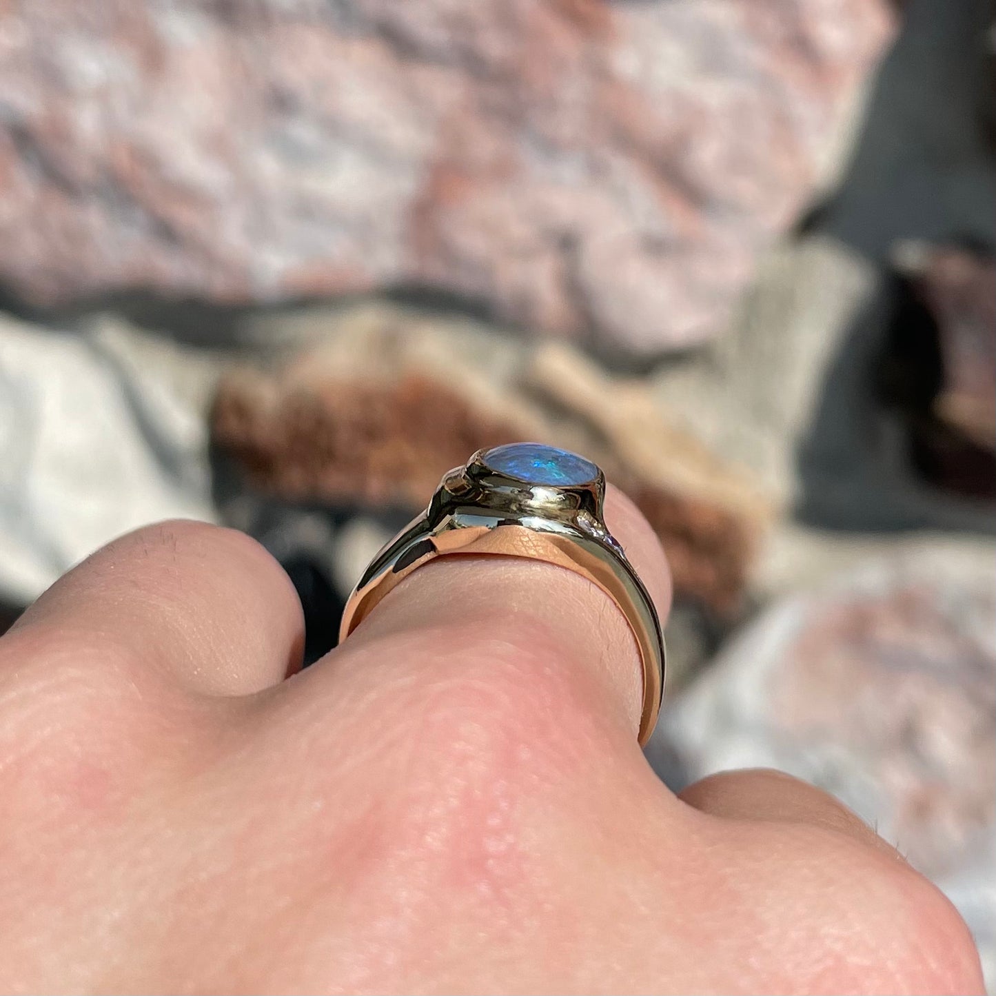 A yellow gold ring set with diamonds and a Lightning Ridge black opal from Australia.