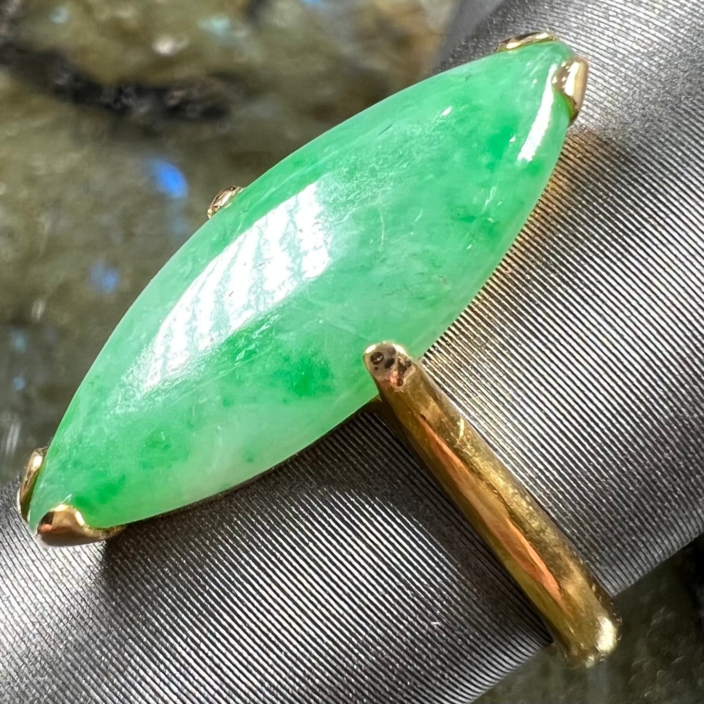 A 22 karat yellow gold solitaire ring set with a marquise cabochon cut green jadeite.