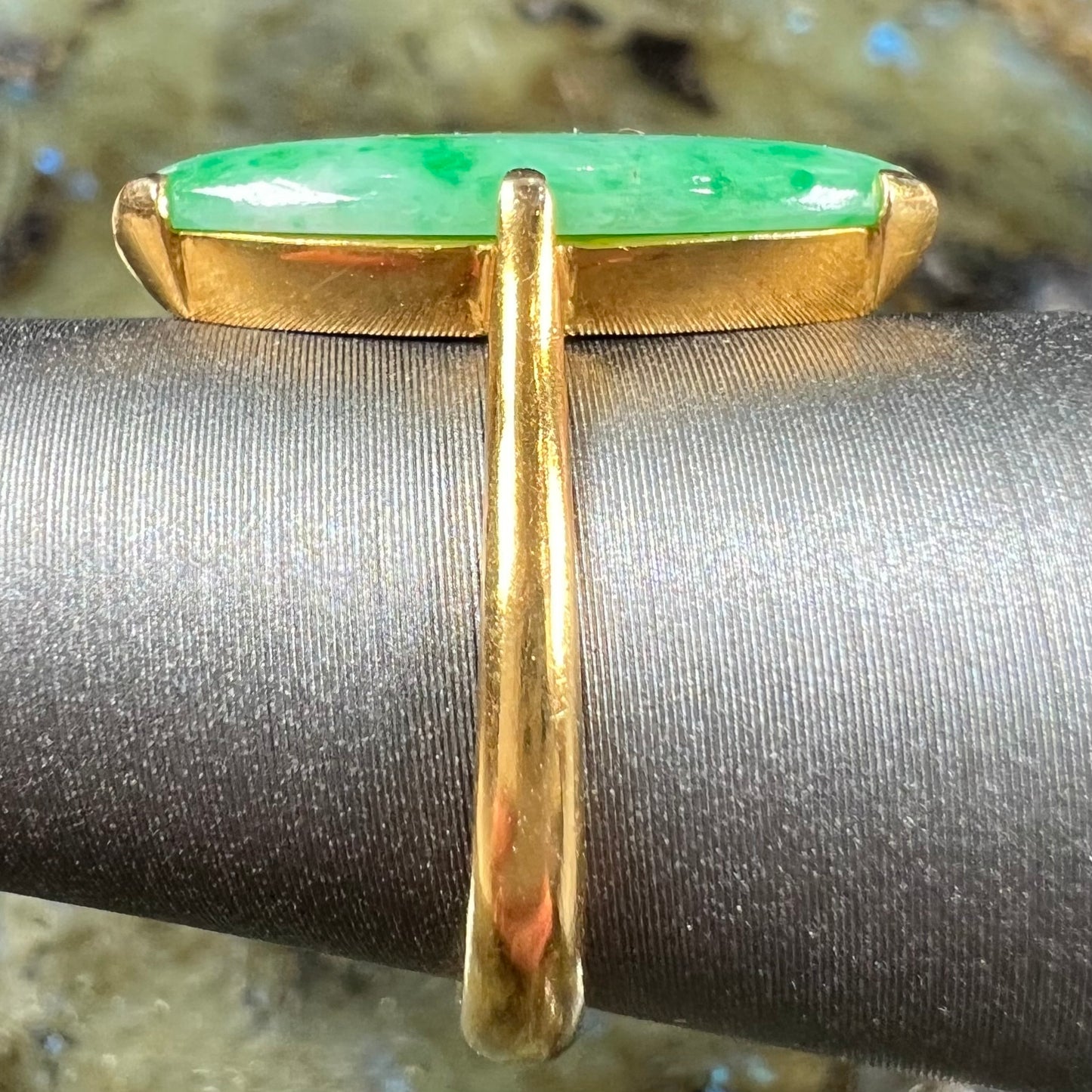 A 22 karat yellow gold solitaire ring set with a marquise cabochon cut green jadeite.