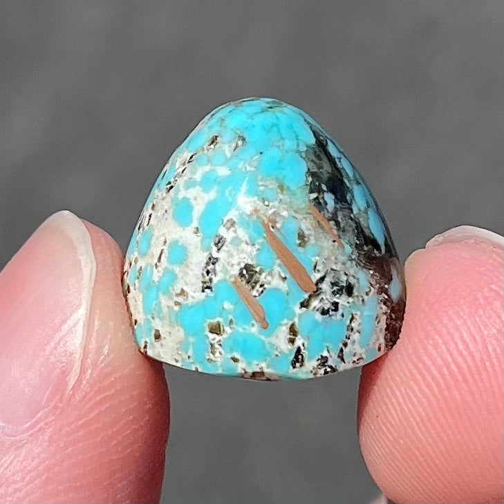 A loose, multicolored, round cabochon cut turquoise stone from Valley Blue Mine in Lander County, Nevada.