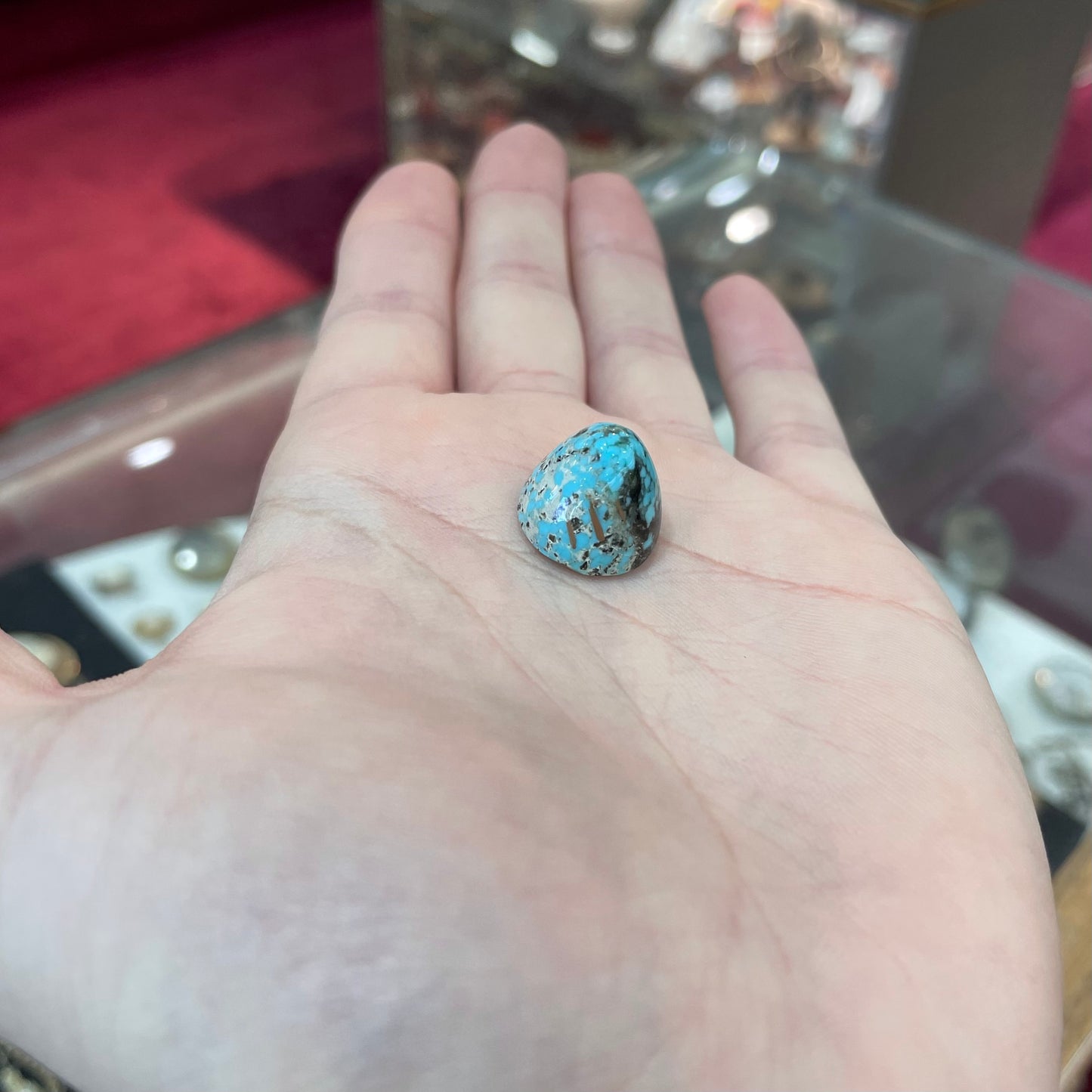 A loose, multicolored, round cabochon cut turquoise stone from Valley Blue Mine in Lander County, Nevada.