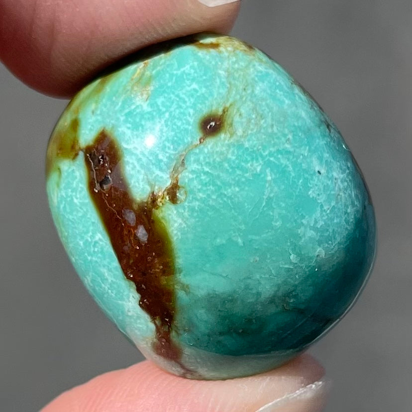 A loose, cushion shaped cabochon cut turquoise stone from Royston District, Nevada.