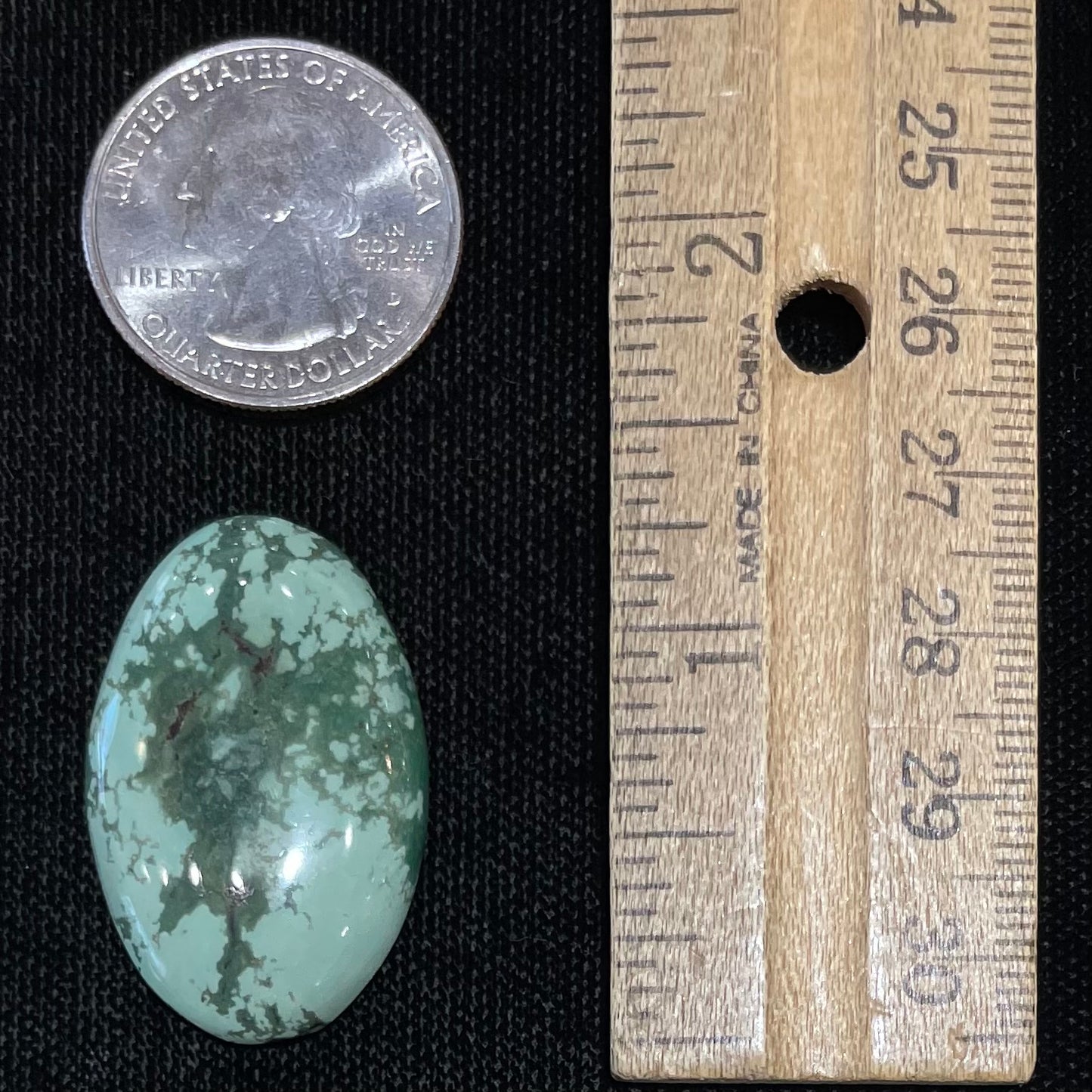 A loose, oval cabochon cut variscite stone from Utah, USA.