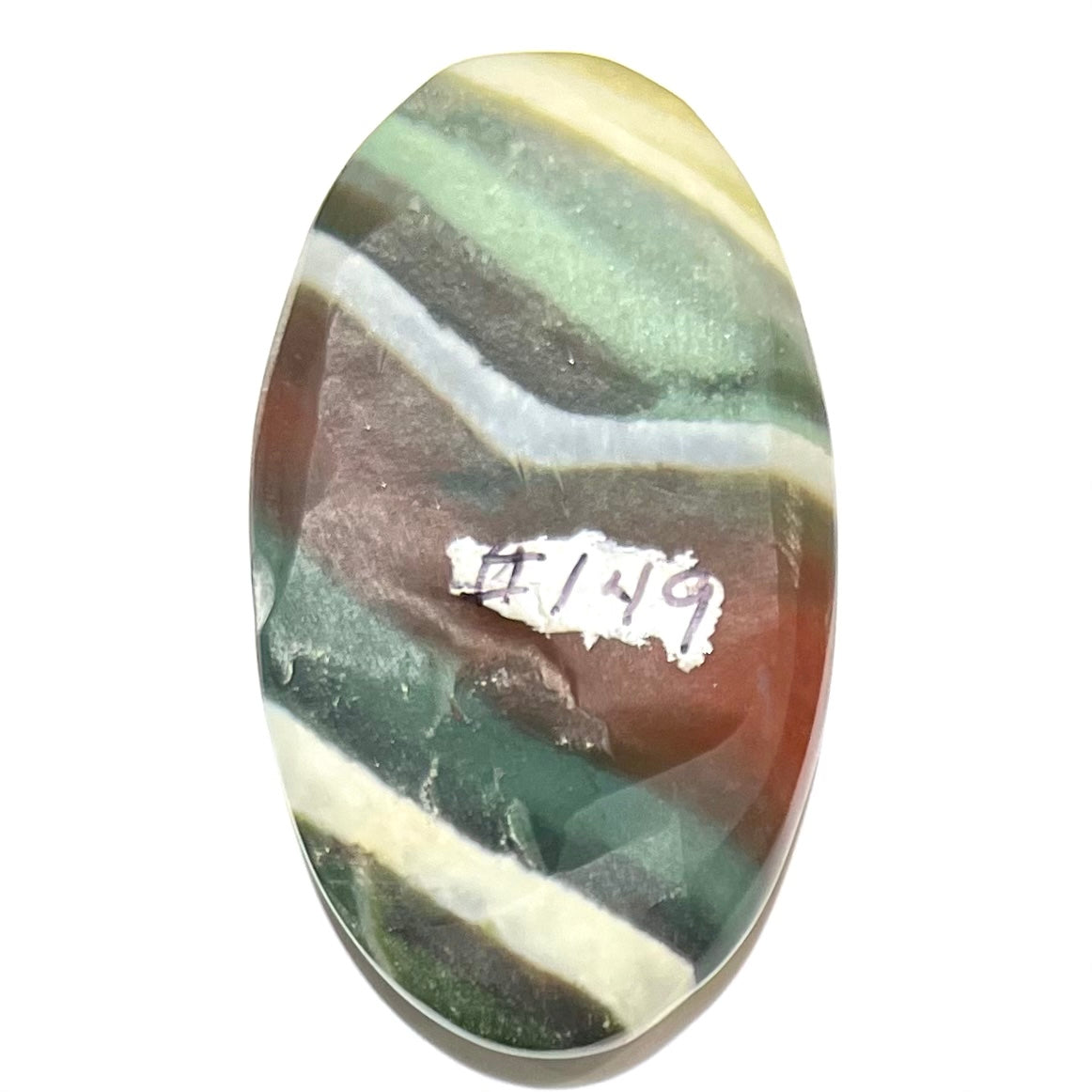 Loose Arizona agate cabochon for sale set on white background. Stone is striped with red, green, and white.