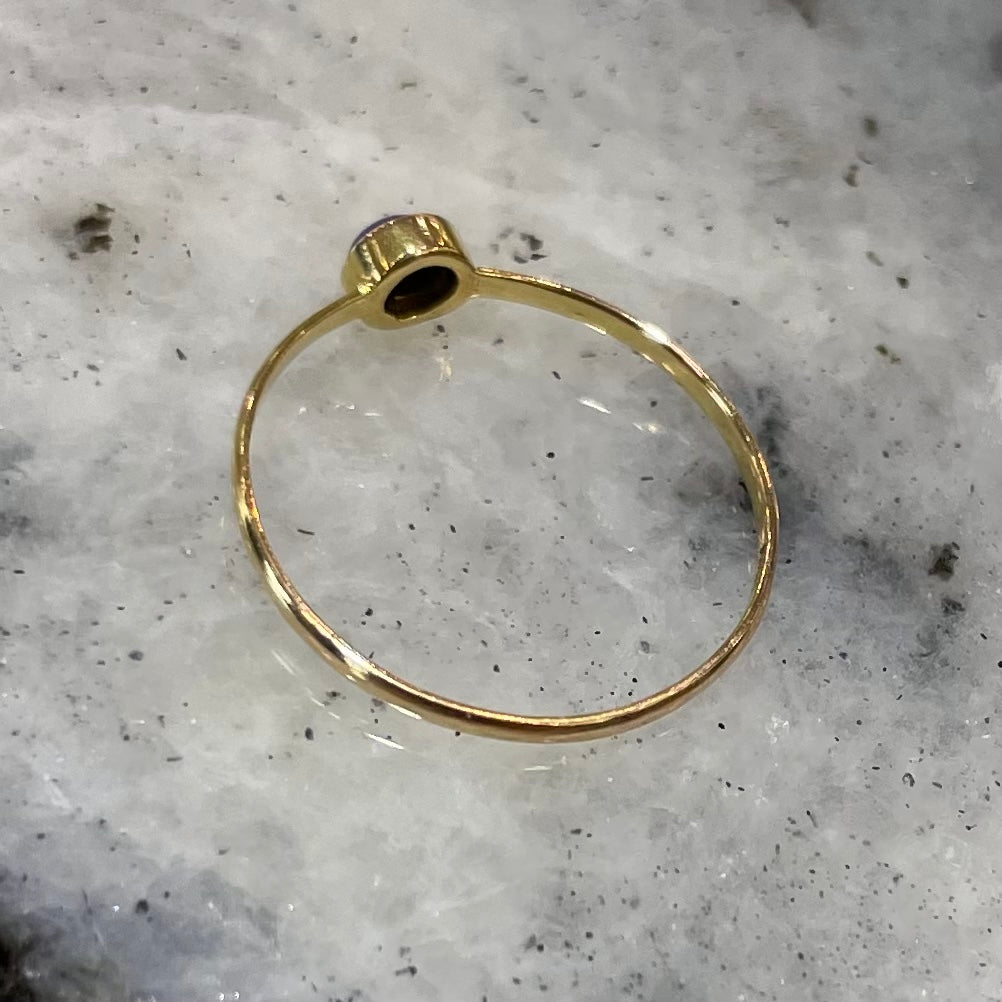 Round cabochon cut blue lapis lazuli stone set in a dainty simple yellow gold solitaire ring.