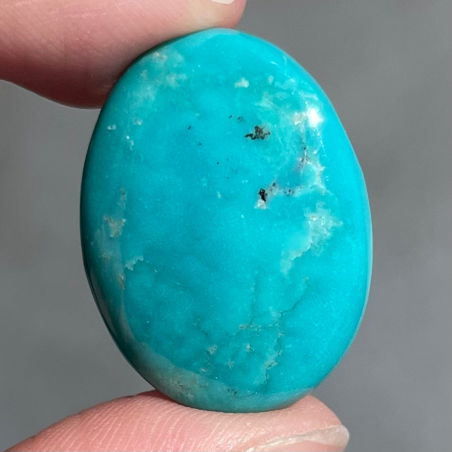 A loose, oval cabochon cut blue turquoise stone from Royston Mining District, Nevada.
