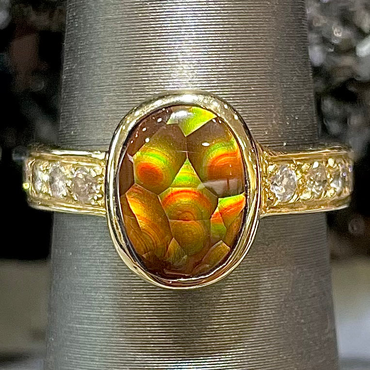 A ladies' oval cabochon cut fire agate and diamond engagement ring cast in yellow gold.