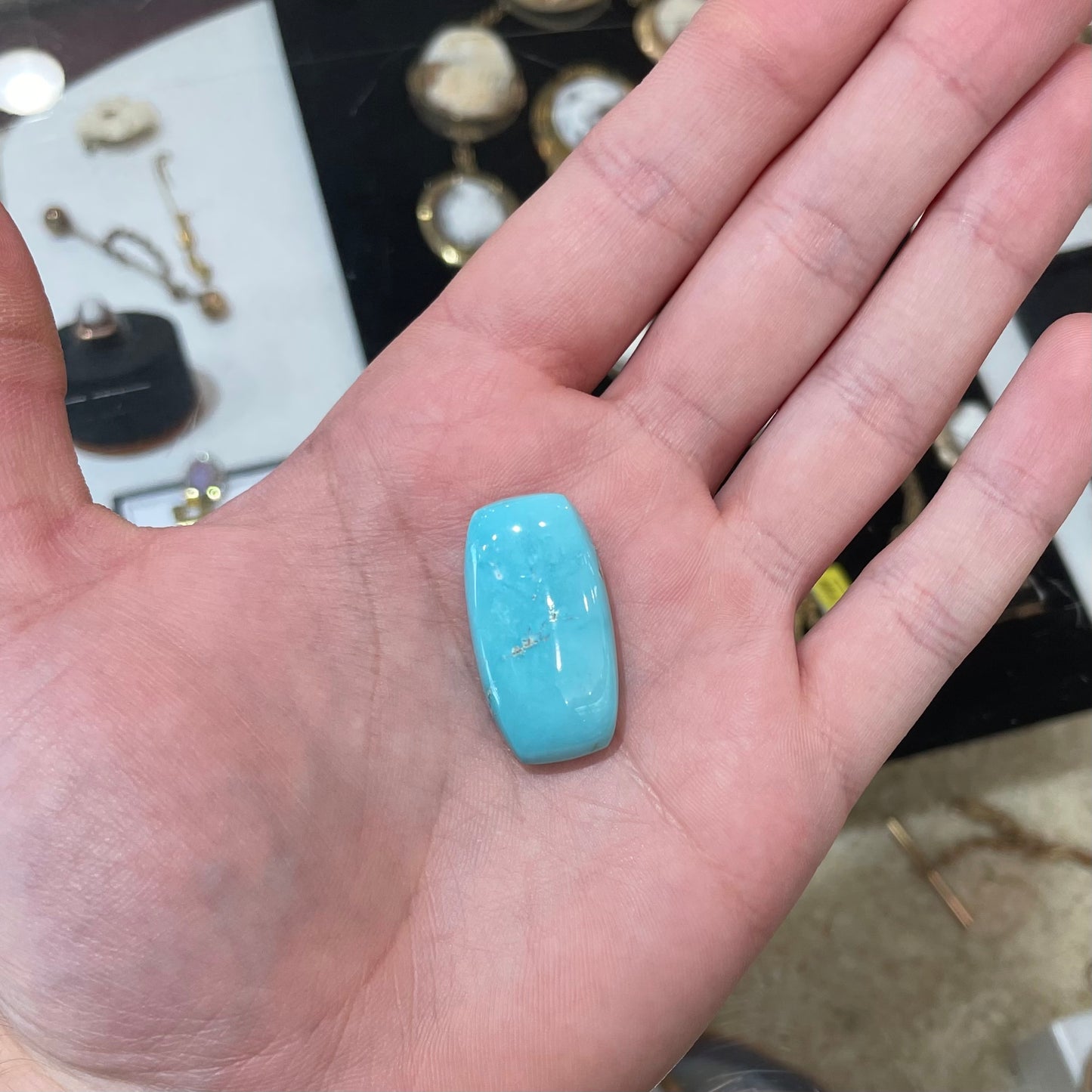 A loose, barrel cabochon cut sky blue turquoise stone from Sleeping Beauty Mine, Arizona.