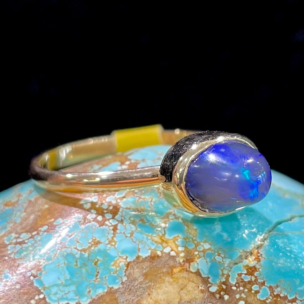 A ladies' black crystal opal solitaire ring set in yellow gold.