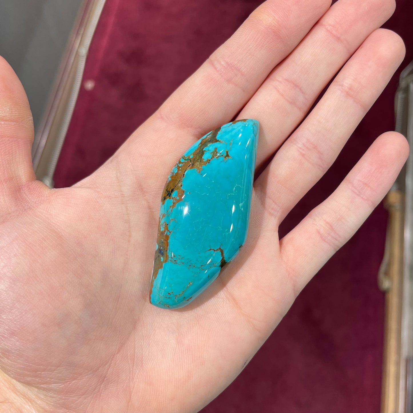 A freeform cabochon cut Bisbee turquoise stone. The stone has been dyed to improve color.