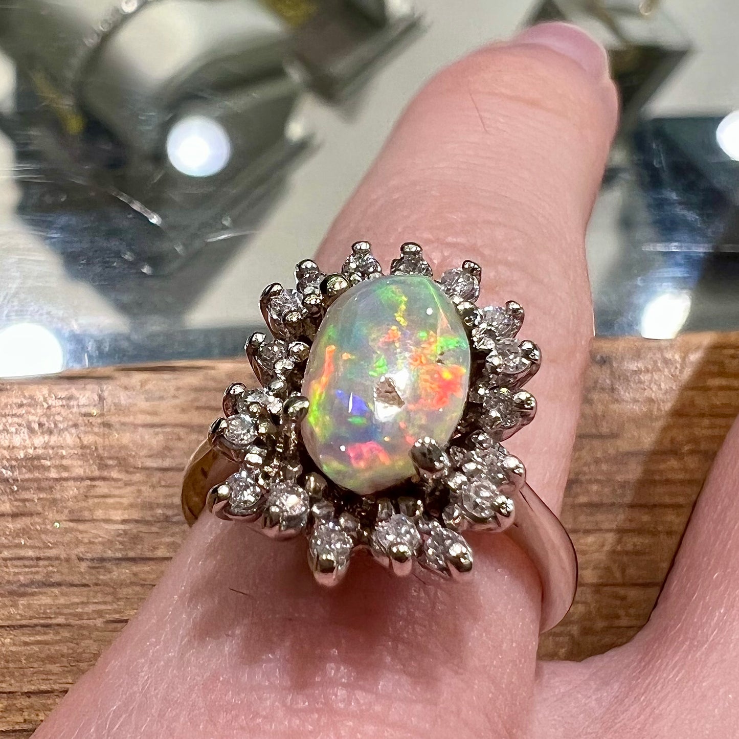 A white crystal opal ring cast in white gold with a halo of round cut diamonds.