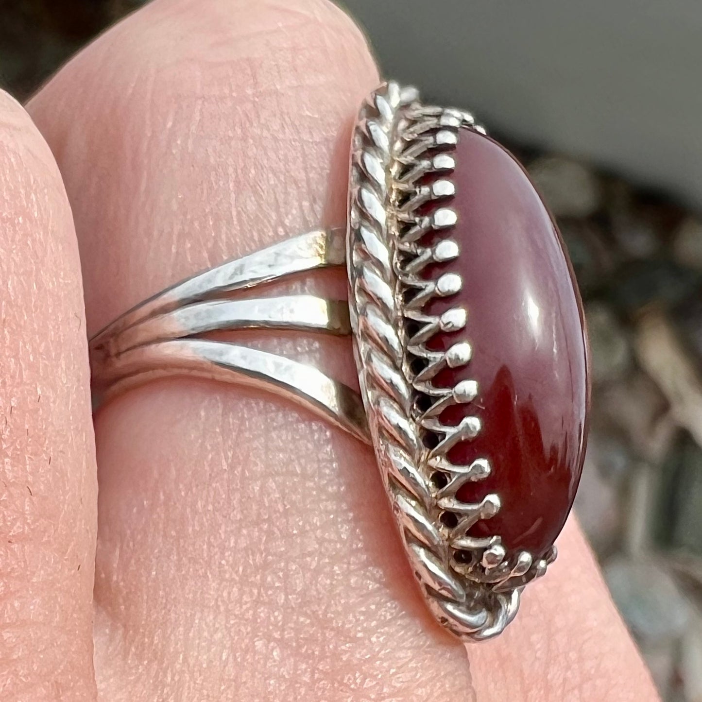 A split shank silver ring set with a brown sard stone in a rope bezel with small prongs.