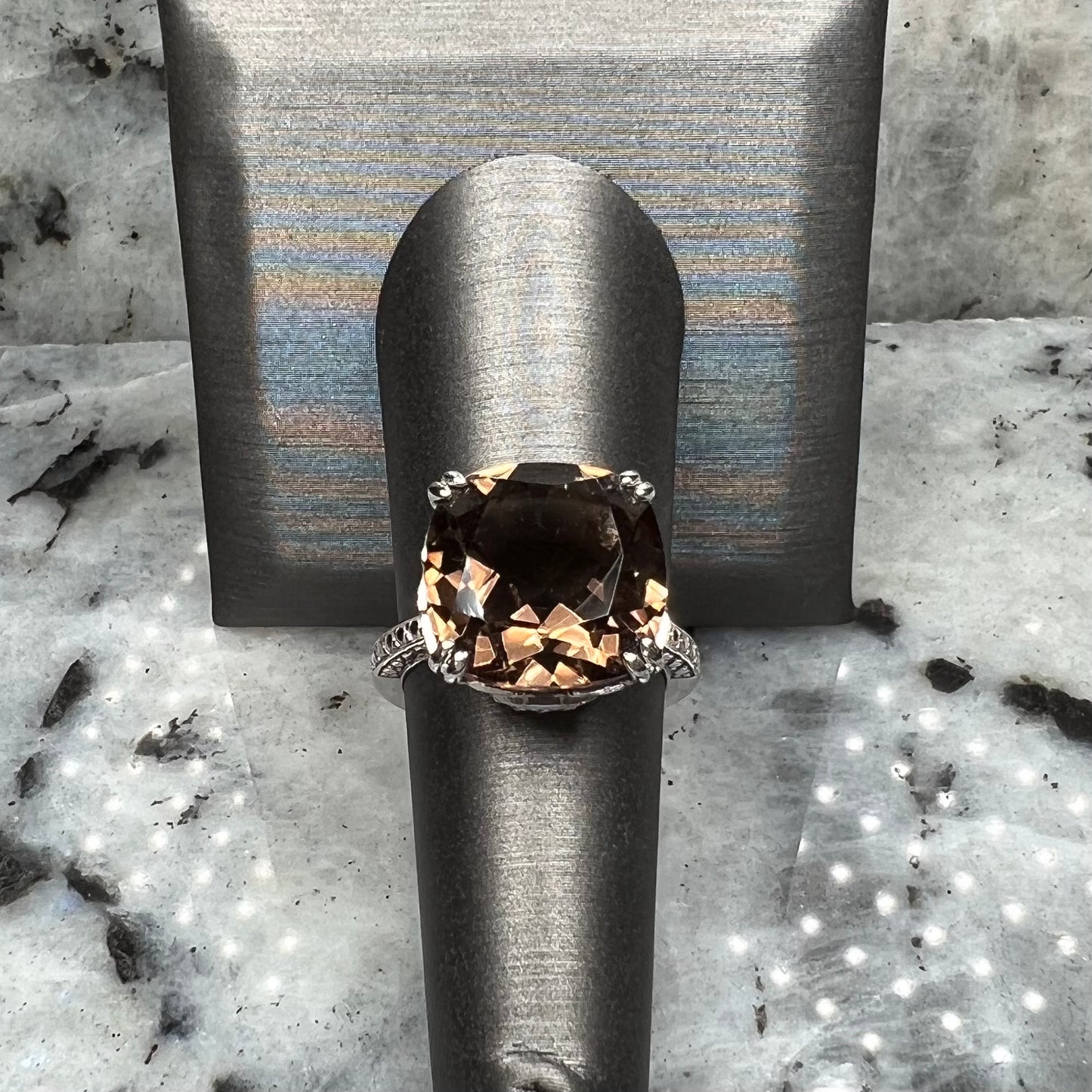A sterling silver, cushion cut smoky quartz solitaire ring.