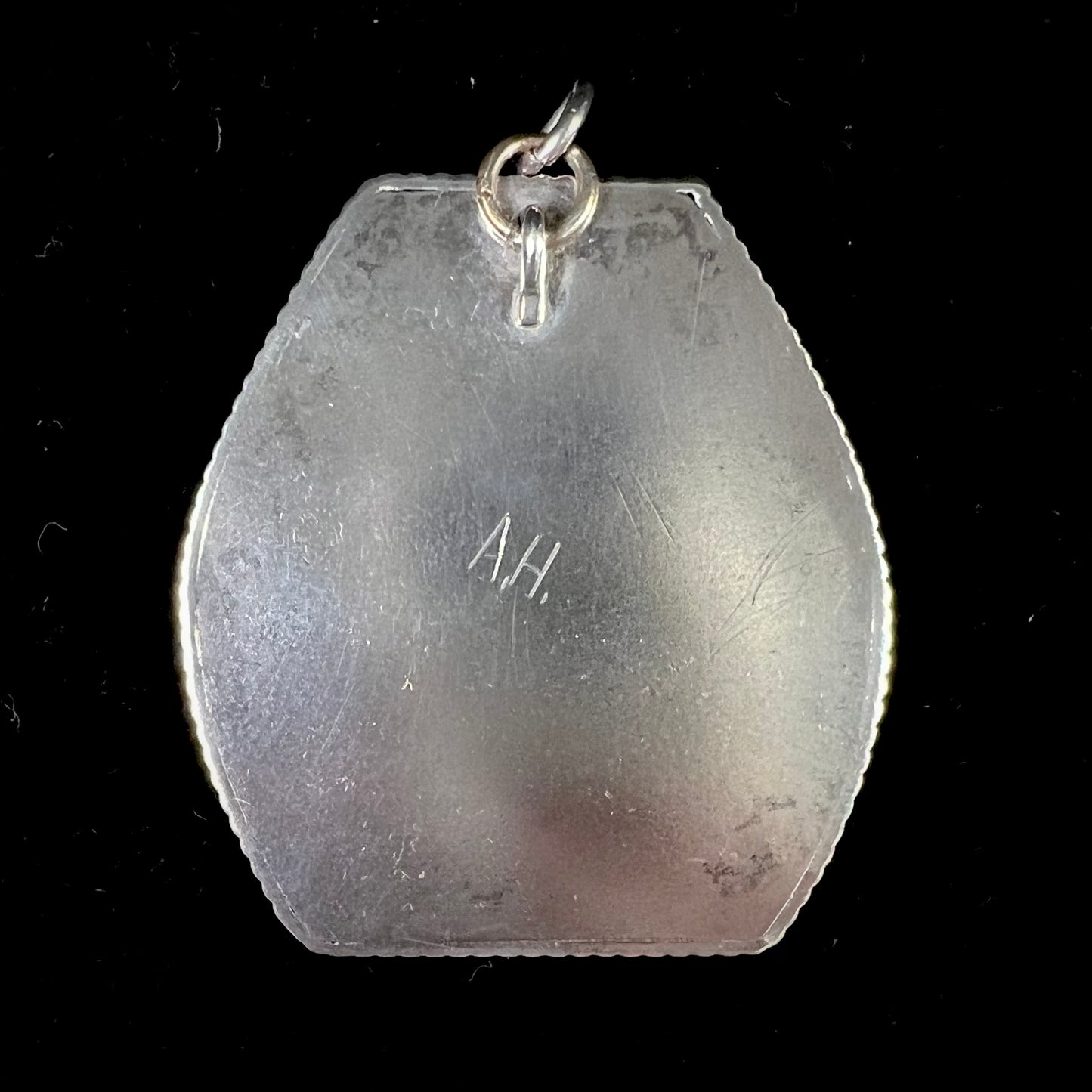 A sterling silver turquoise and polished coral branch pendant. The back of the piece is signed "A.H."