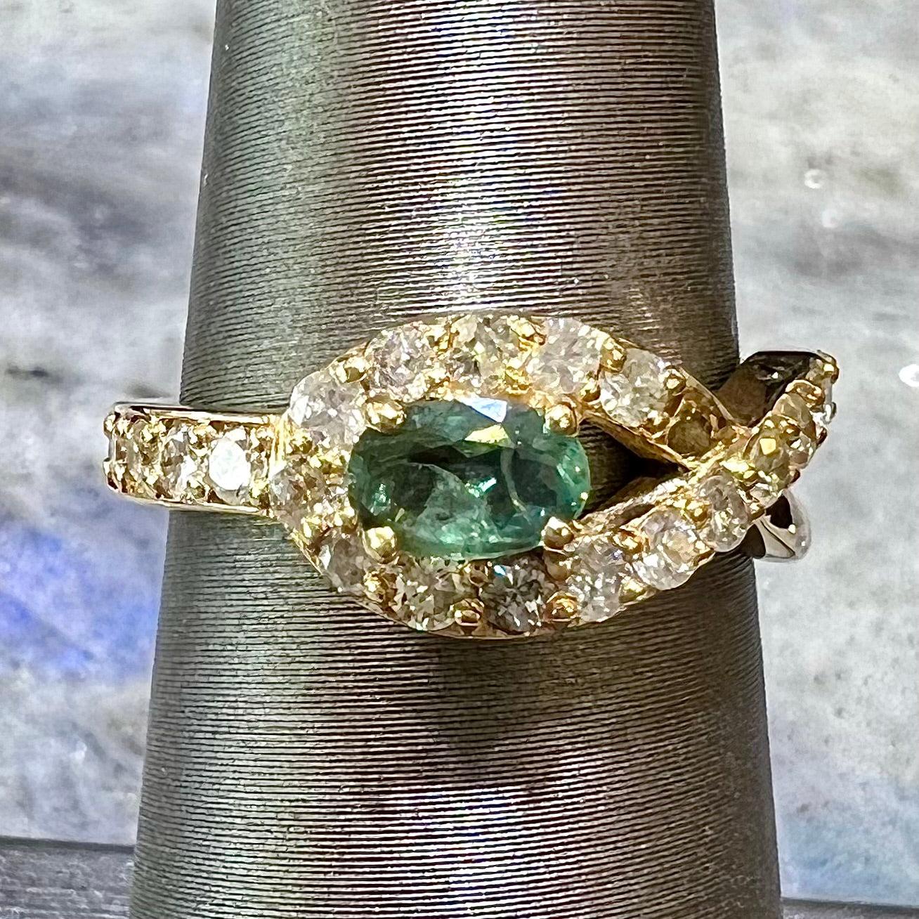 Yellow gold alexandrite and pave set diamond ladies' ring on ring stand.