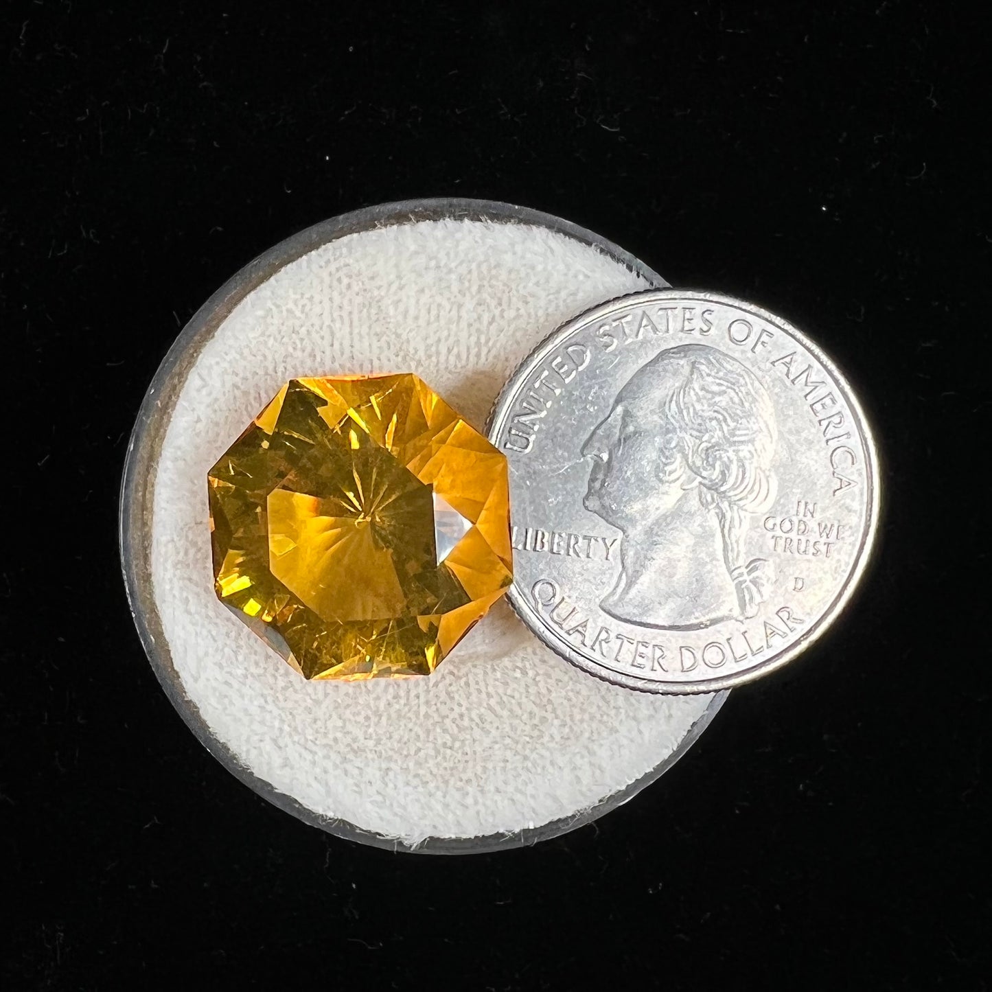 A loose, faceted octagonal cut golden amber stone. There are no bug inclusions visible.
