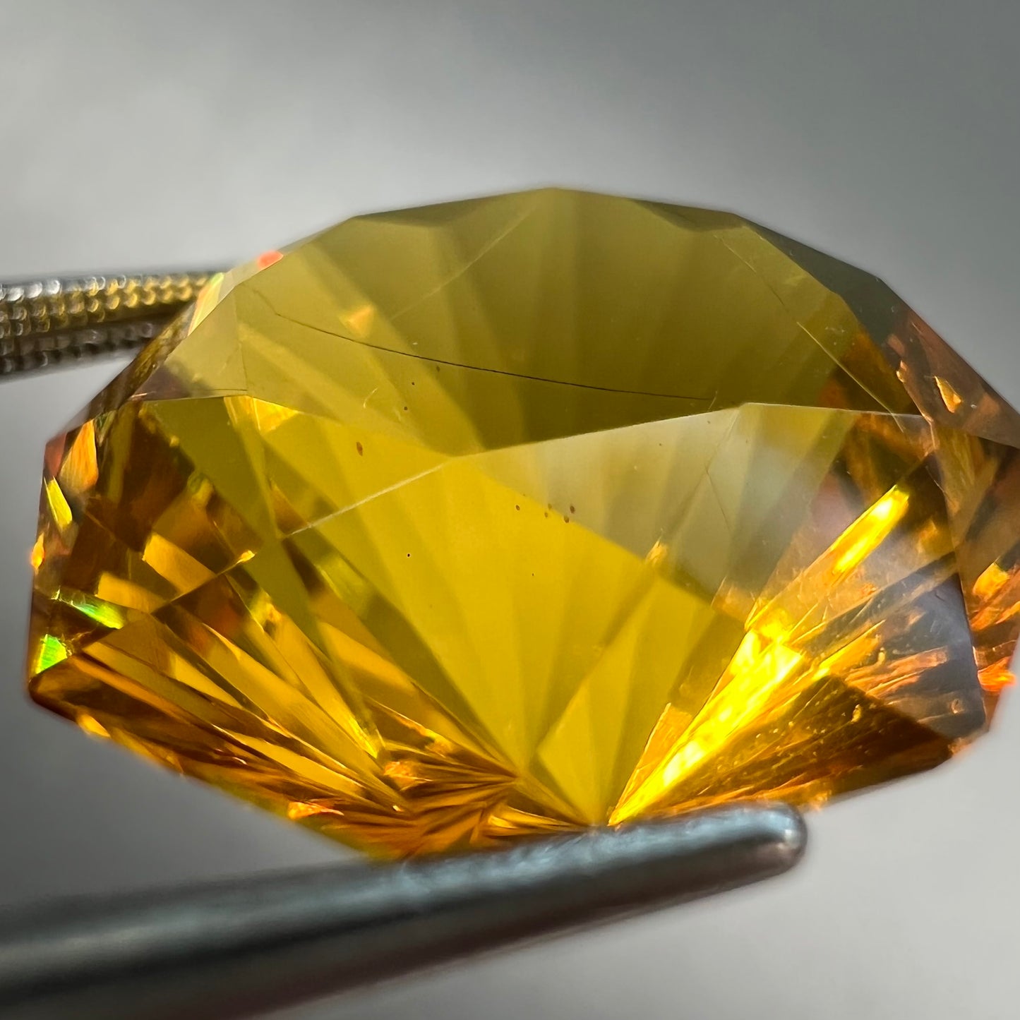 A loose, faceted octagonal cut golden amber stone. There are no bug inclusions visible.