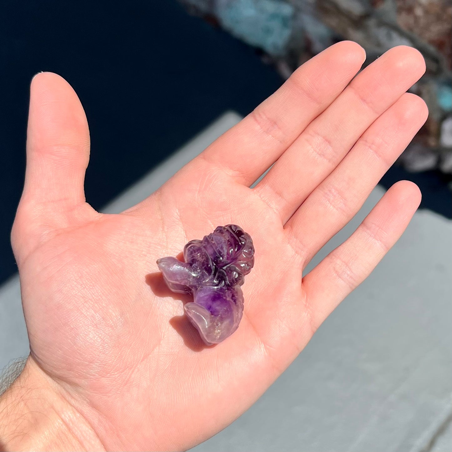 A stone foo dog carving carved from a purple Brazilian amethyst crystal.