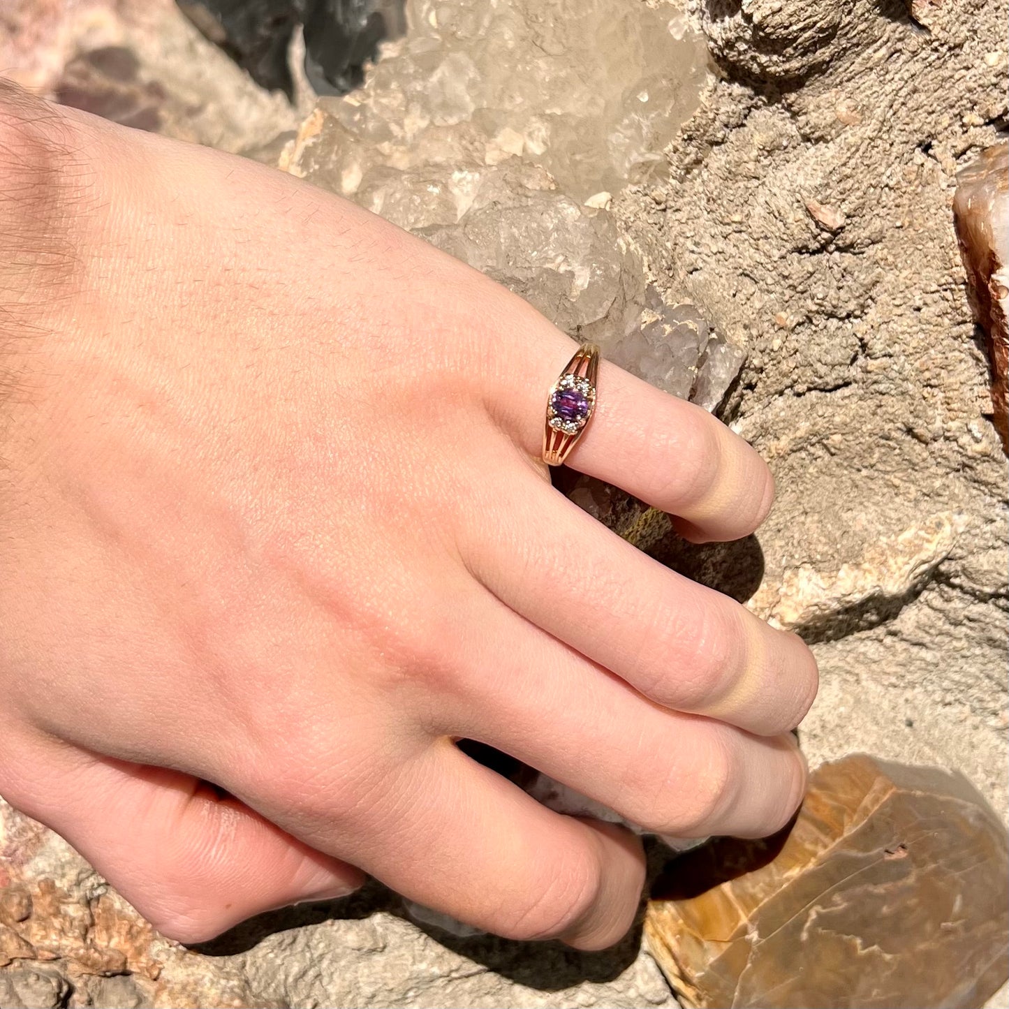 A ladies split shank gold ring set with an oval cut amethyst and round brilliant diamond accents.