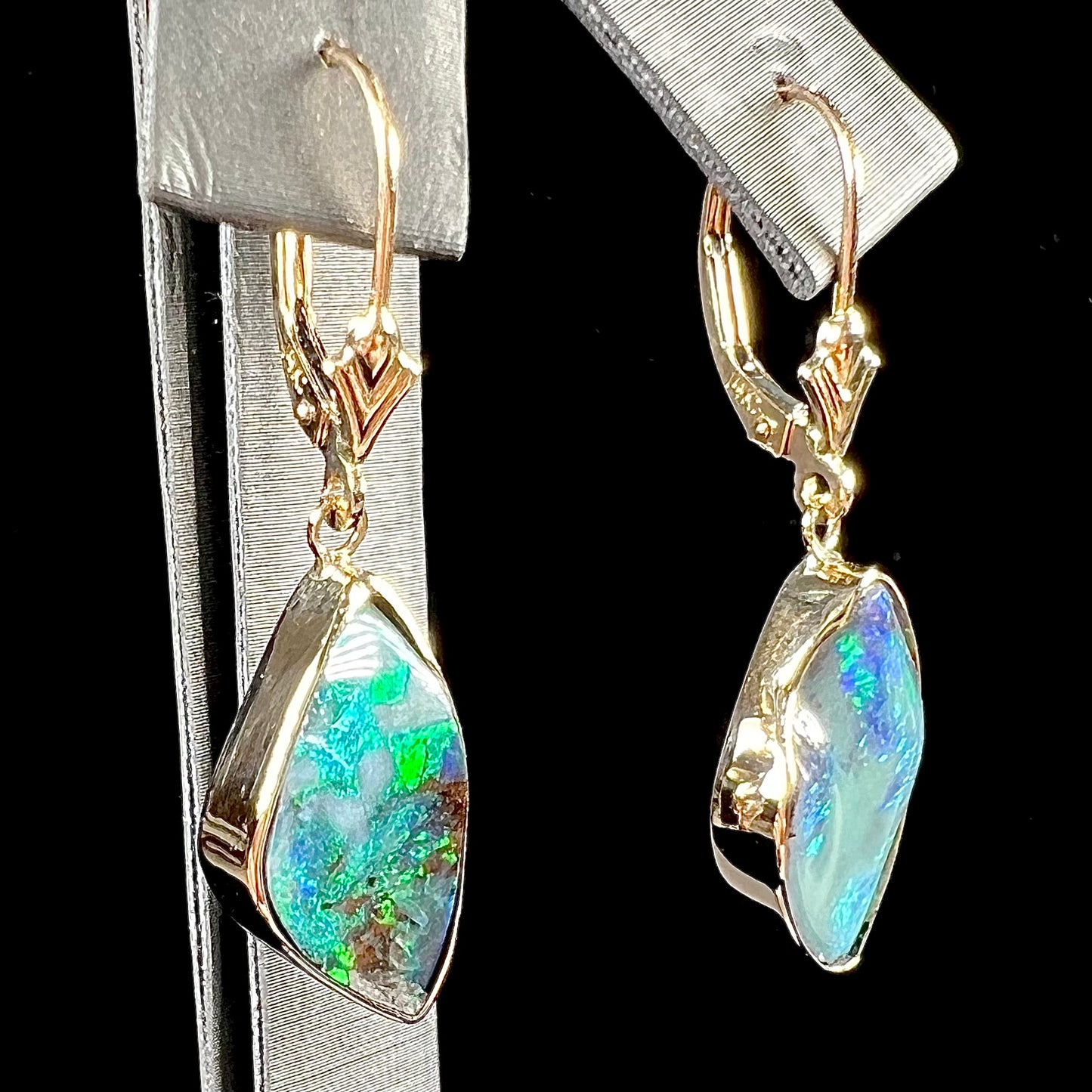 A pair of yellow gold dangle earrings set with Australian boulder opal stones.