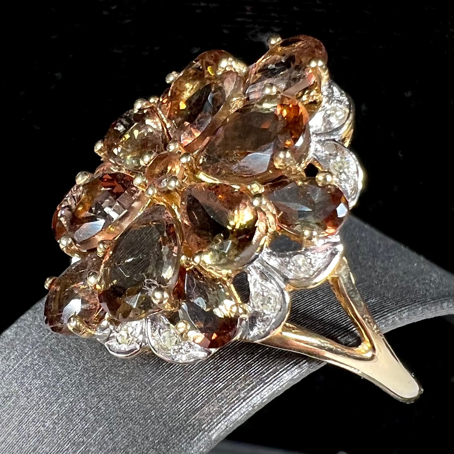 A yellow gold andalusite and diamond cluster ring.