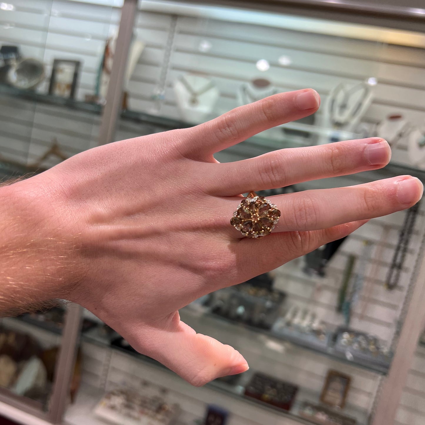 A yellow gold andalusite and diamond cluster ring.