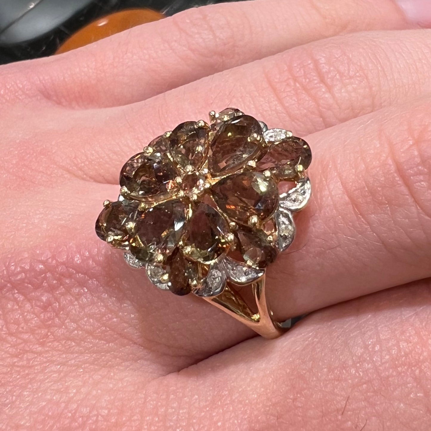 A yellow gold andalusite and diamond cluster ring.