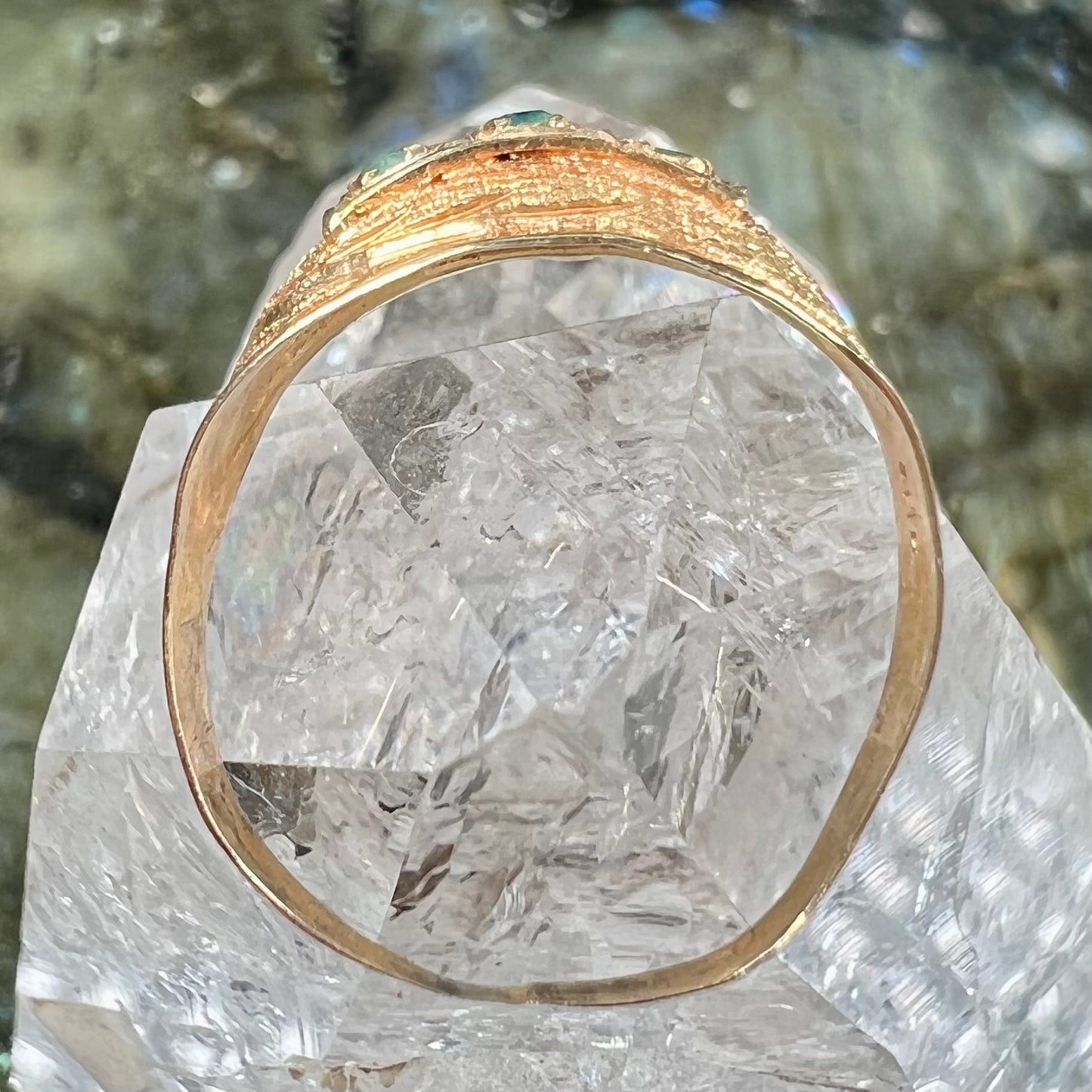 A 1920's style yellow gold three stone round cut emerald ring.