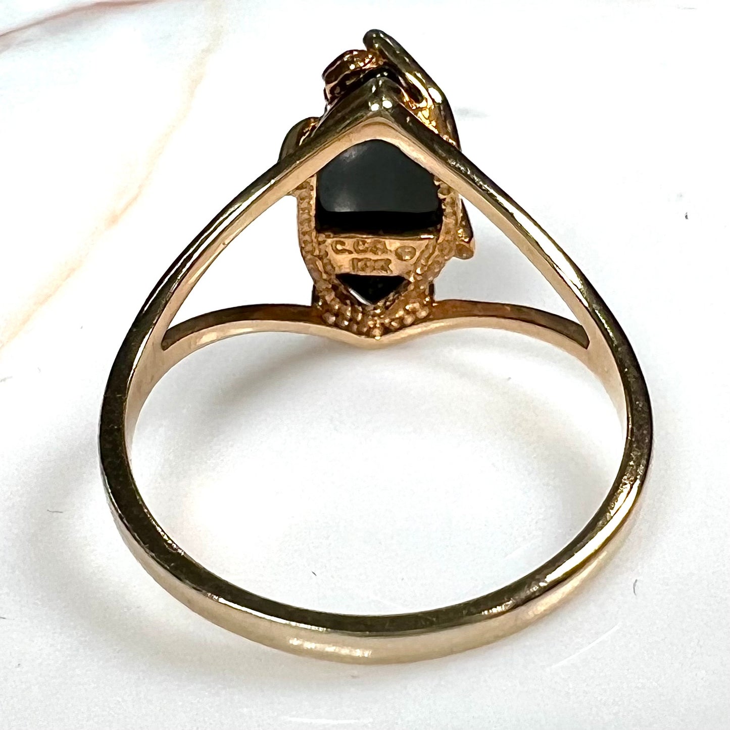 A split shank Black Hills gold ring set with a cabochon marquise cut black onyx.