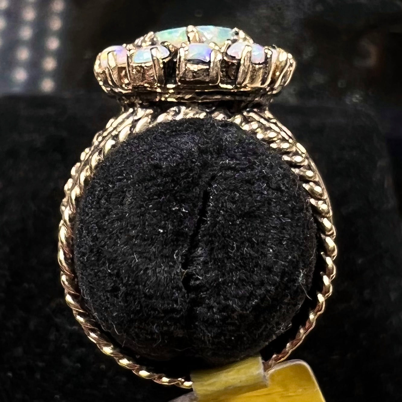 Vintage yellow gold oval opal cabochon ring set with 12 round opals in a halo around the center stone.