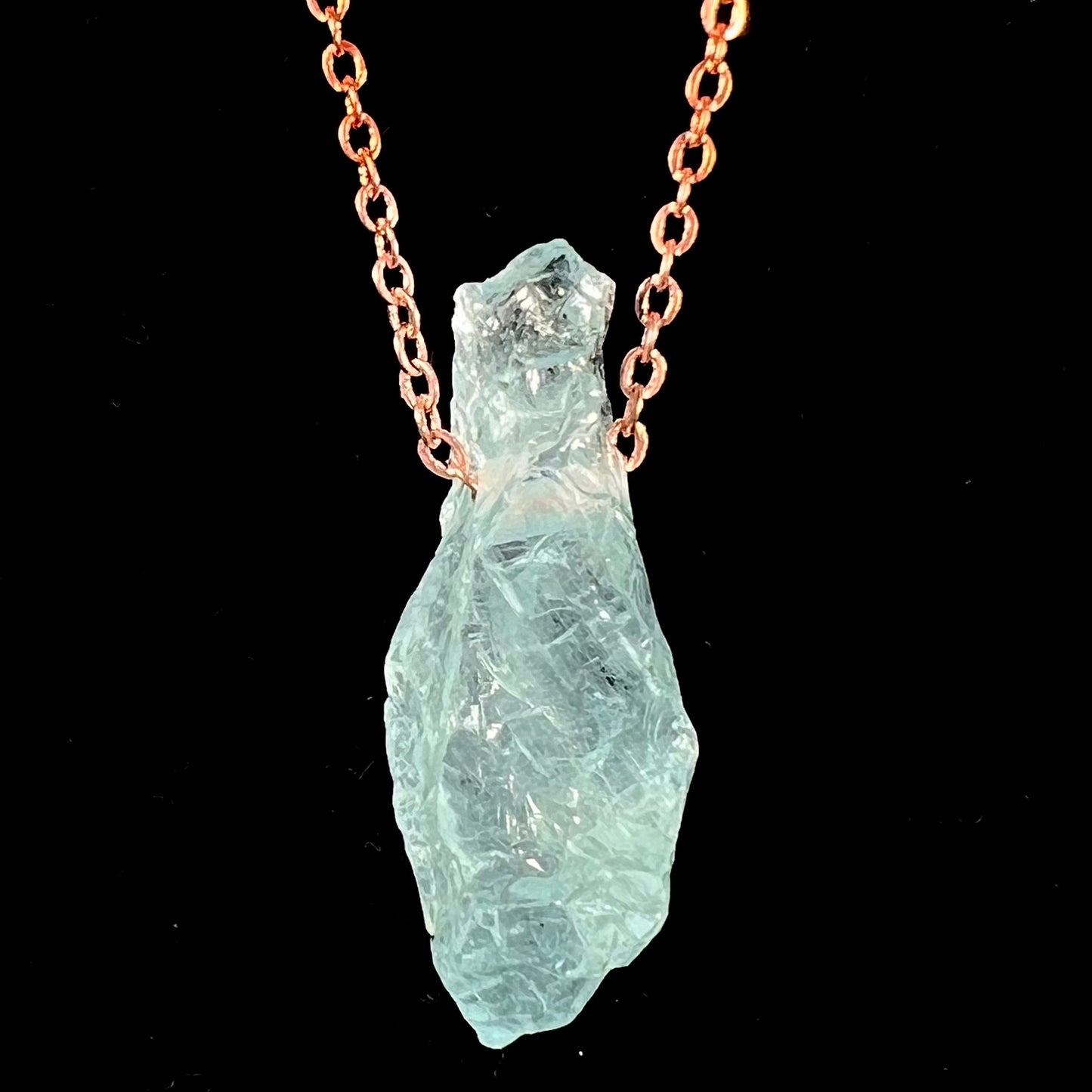 A drilled aquamarine crystal necklace on a copper cable chain.