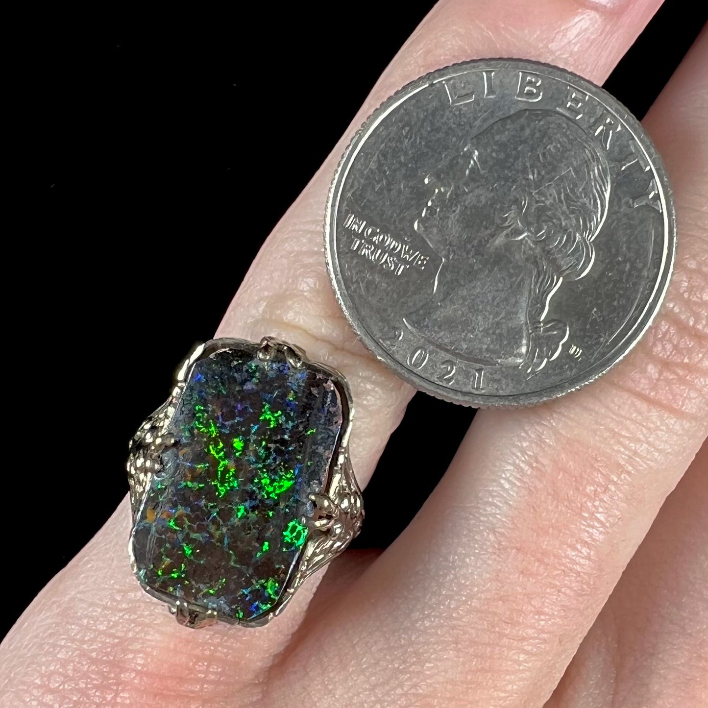 A vintage, white gold filigree unisex ring set with a natural black Koroit boulder opal.