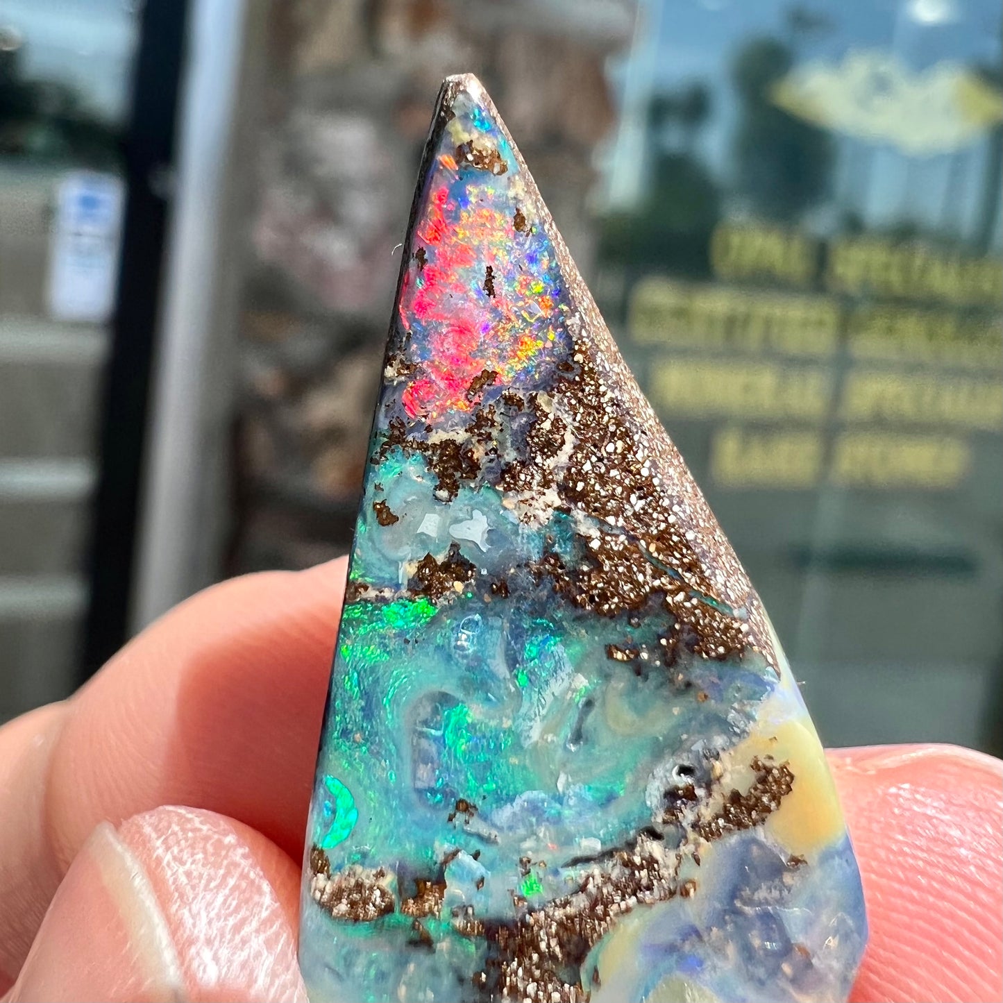 A loose Quilpie boulder opal stone. The stone is blue and has a bright rainbow tip.