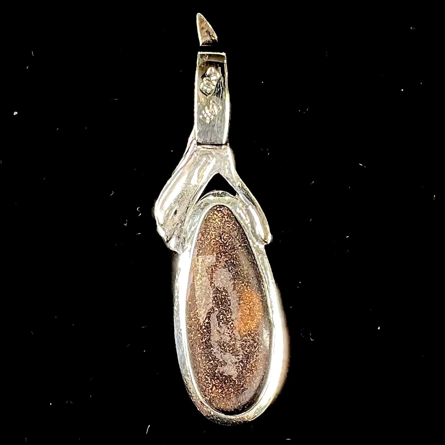A white gold solitaire pendant set with an Quilpie, Australian boulder opal stone. The opal shines a rainbow of colors.