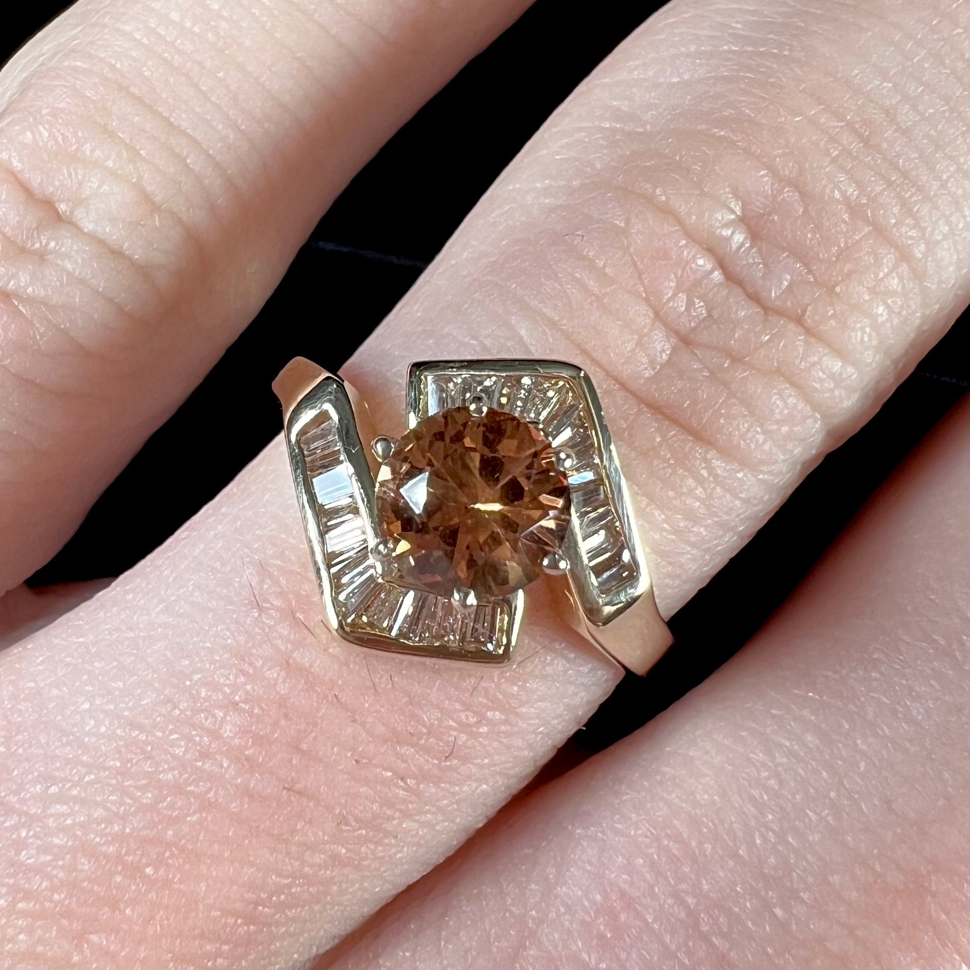 A yellow gold ladies' golden topaz ring set with baguette cut side diamonds.