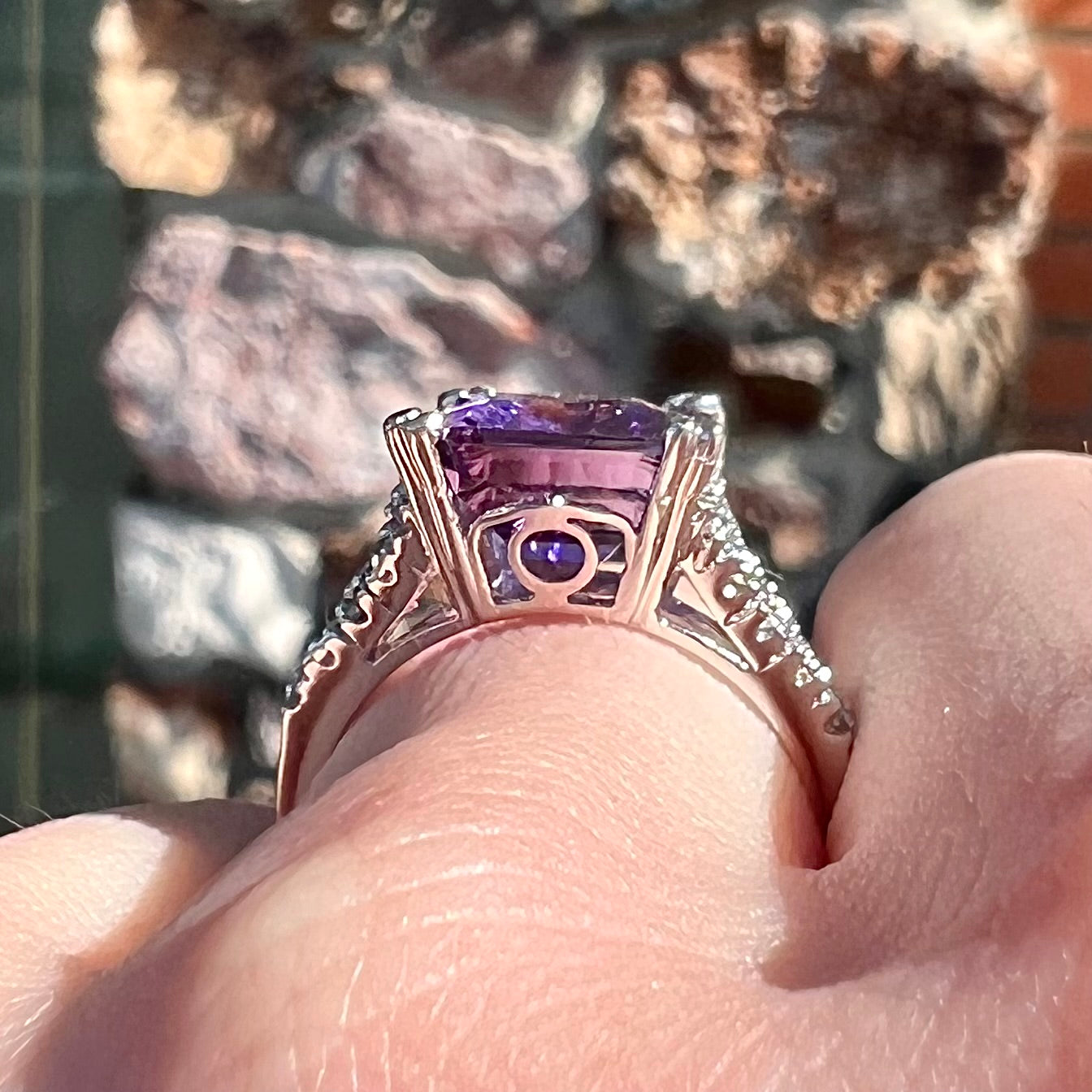 A white gold ladies ring set with an emerald laser cut amethyst and diamond chip accents.