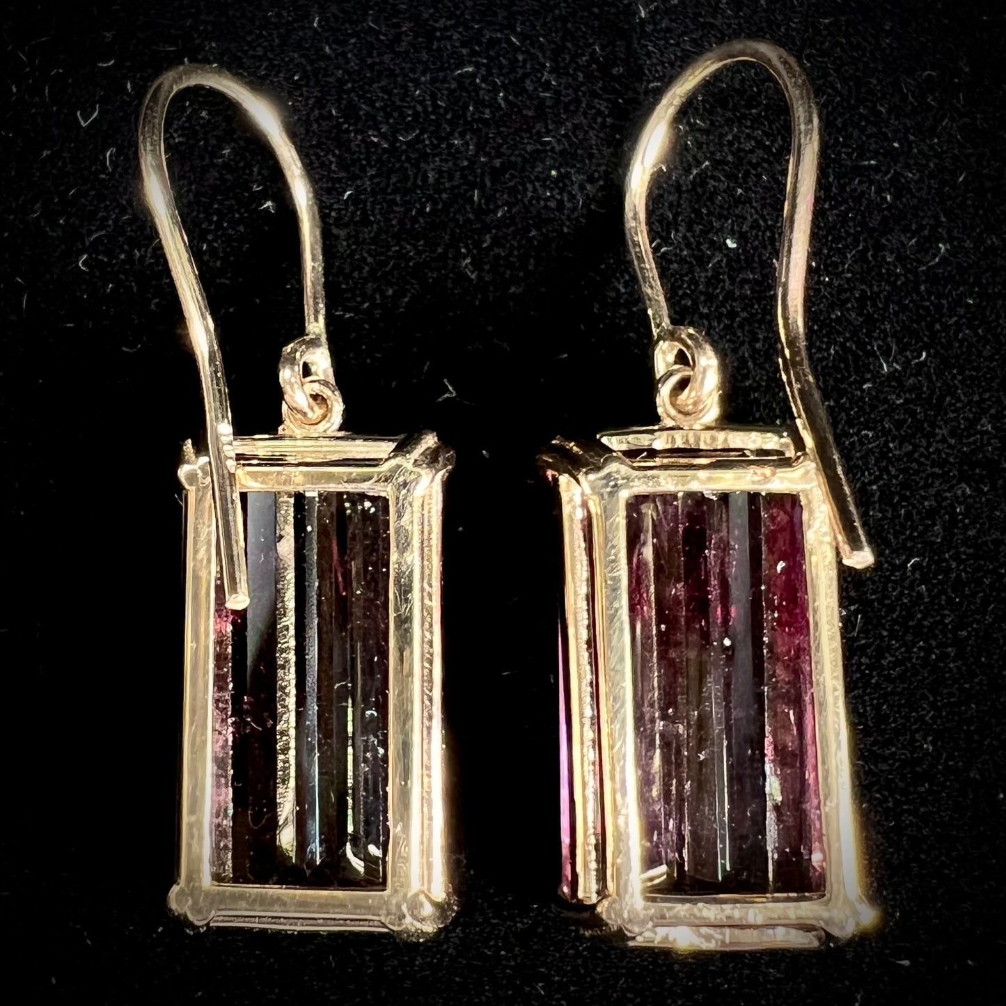 A pair of pink and magenta bicolor tourmaline dangle earrings handmade in 14kt yellow gold with basket settings and shepherd's hooks.