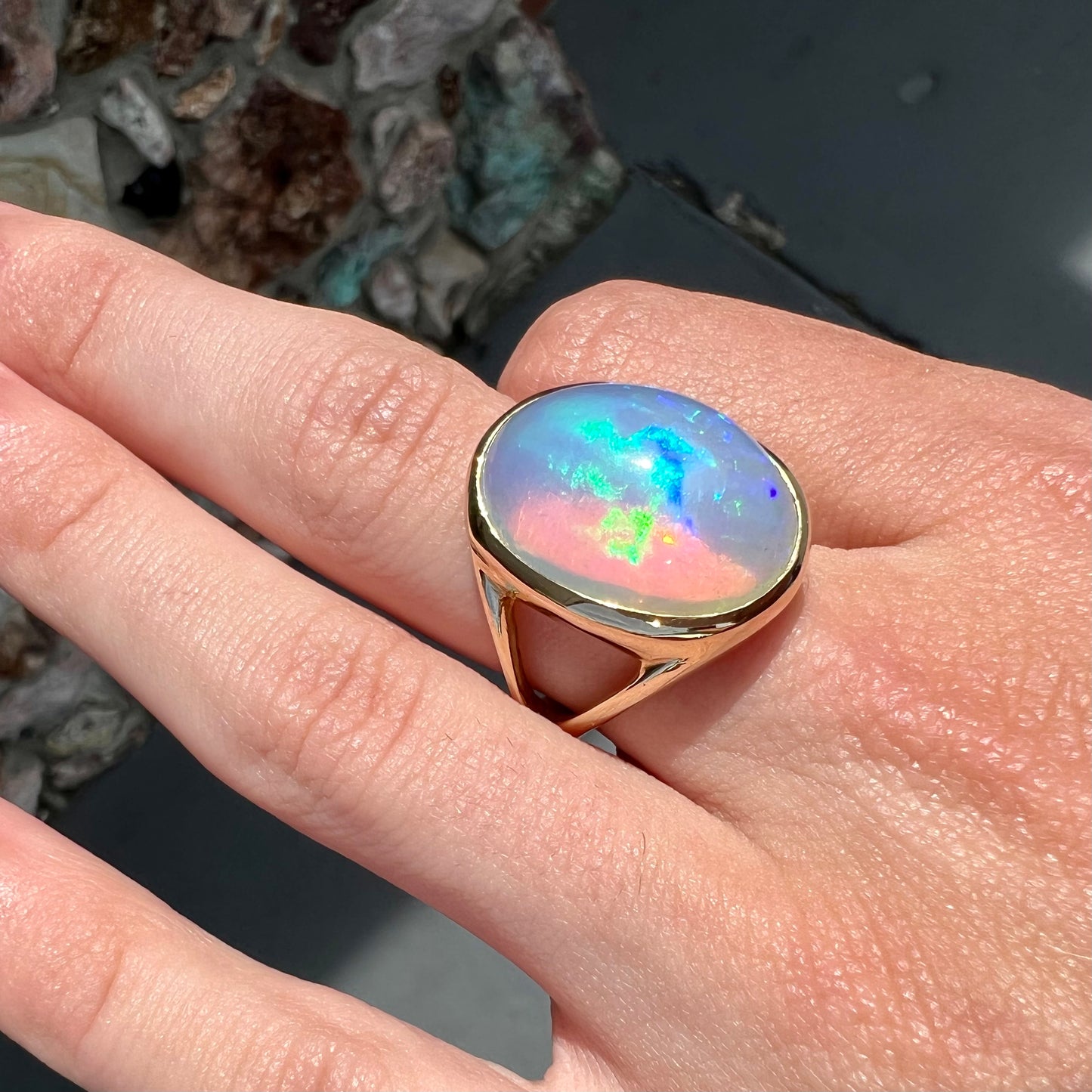 A gold split shank solitaire ring set with an oval cabochon cut 16.83 carat Ethiopian jelly fire opal.