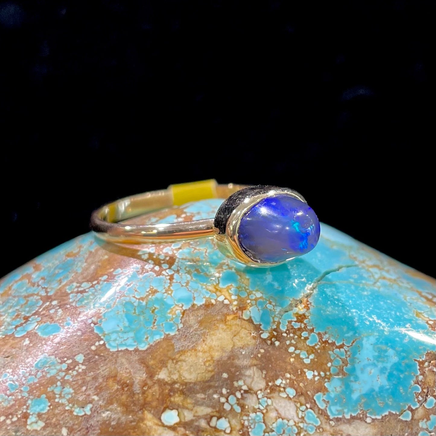 A ladies' black crystal opal solitaire ring set in yellow gold.