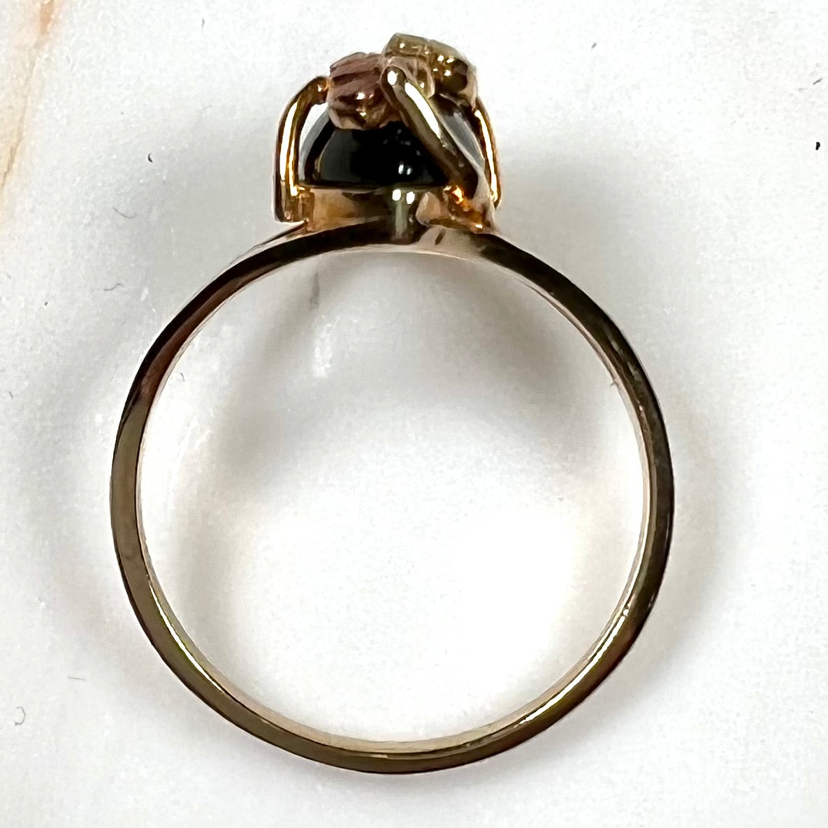 A split shank Black Hills gold ring set with a cabochon marquise cut black onyx.