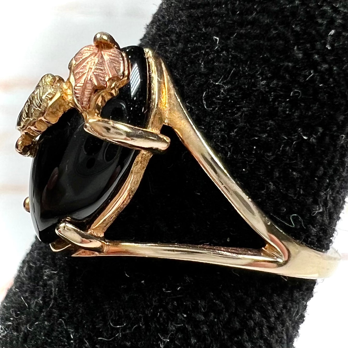 A split shank Black Hills gold ring set with a cabochon marquise cut black onyx.