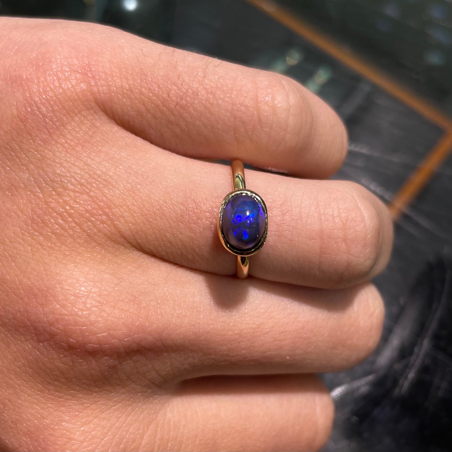 A ladies' black crystal opal solitaire ring set in yellow gold.