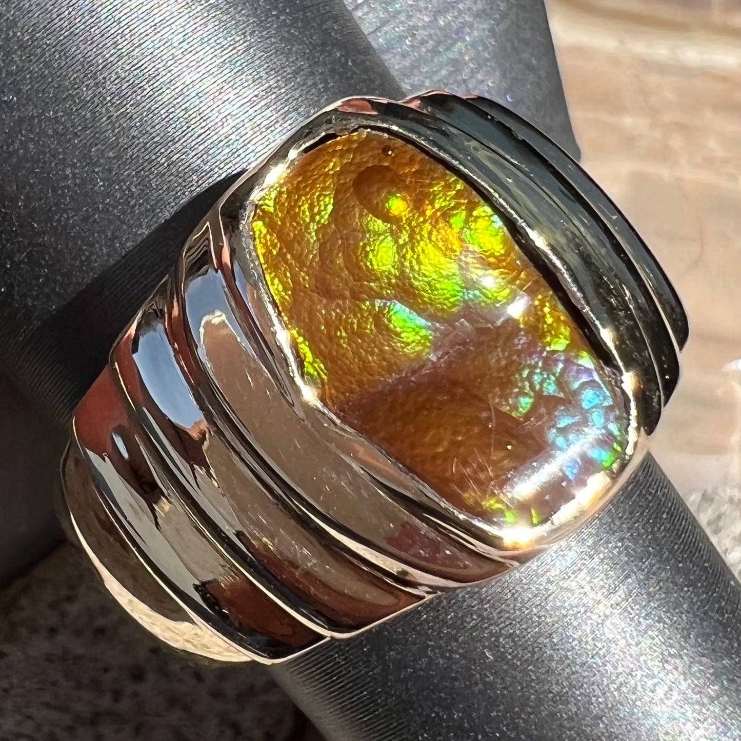 Men's fire agate solitaire ring cast in yellow gold. The ring is a step design.