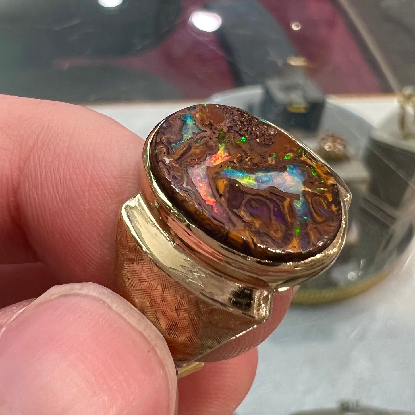 A Koroit boulder opal men's ring in brushed yellow gold.