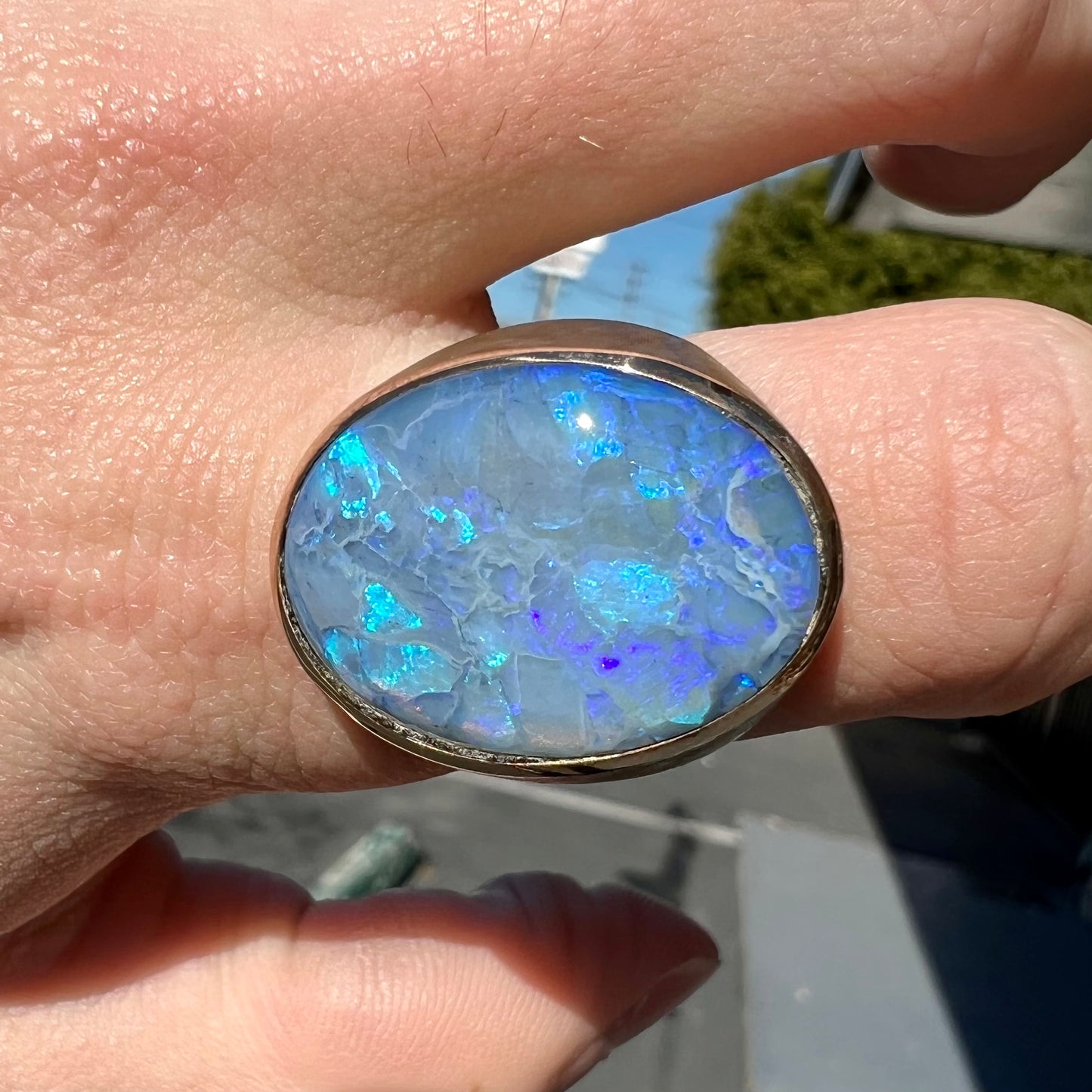 A Lightning Ridge black opal men's ring in solid yellow textured gold.