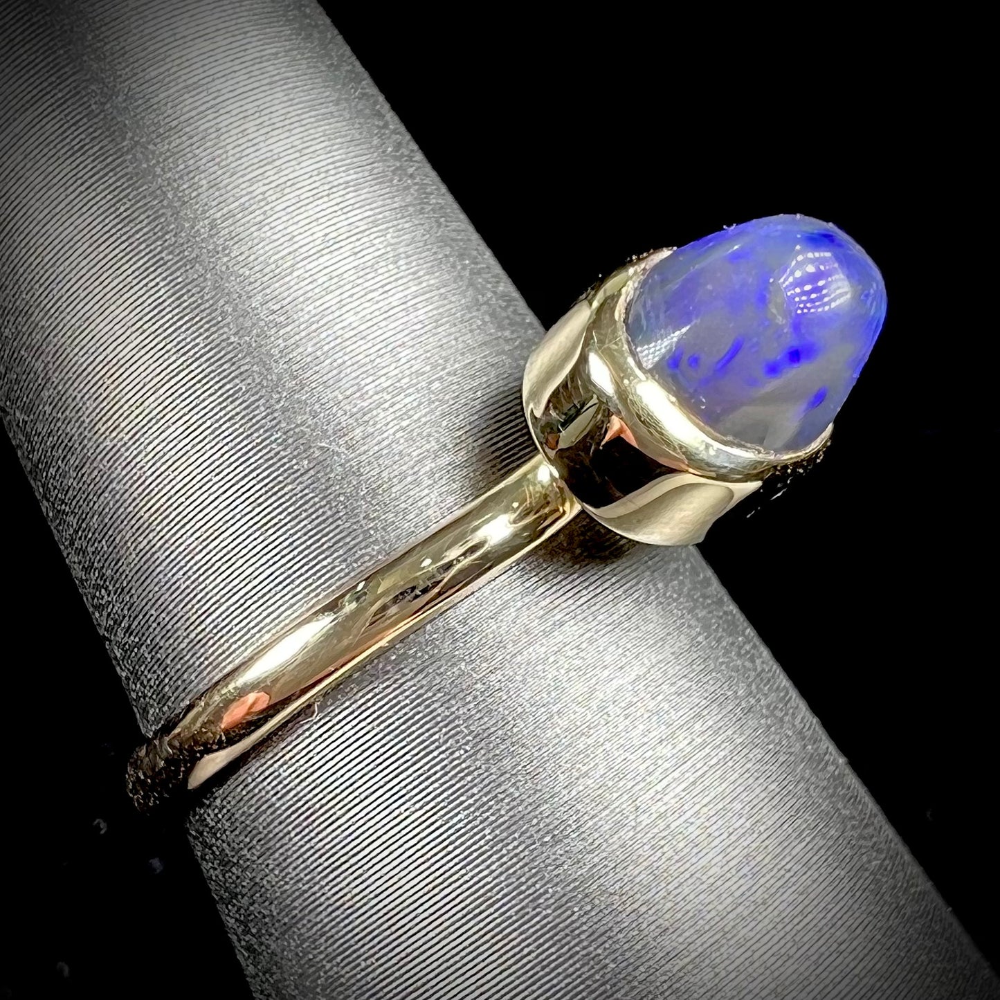 A ladies' black crystal opal solitaire ring set in yellow gold.
