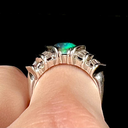 A white gold ring set with a Lightning Ridge natural black opal and baguette cut diamonds.