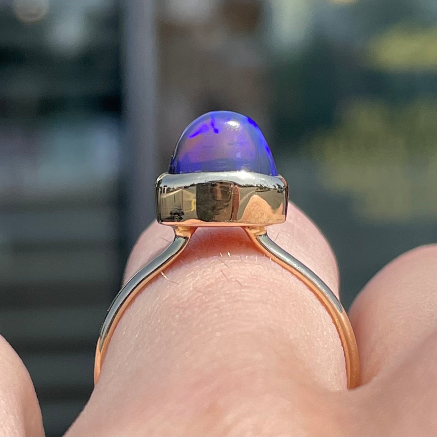 A ladies' black crystal opal solitaire ring set in yellow gold.