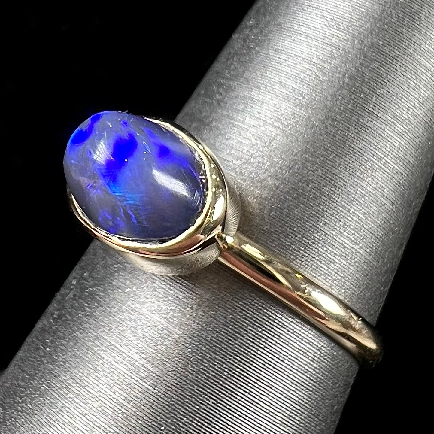 A ladies' black crystal opal solitaire ring set in yellow gold.